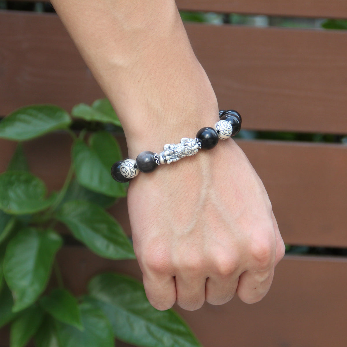 Wish-fulfilling (Ruyi) bead detail on obsidian bracelet